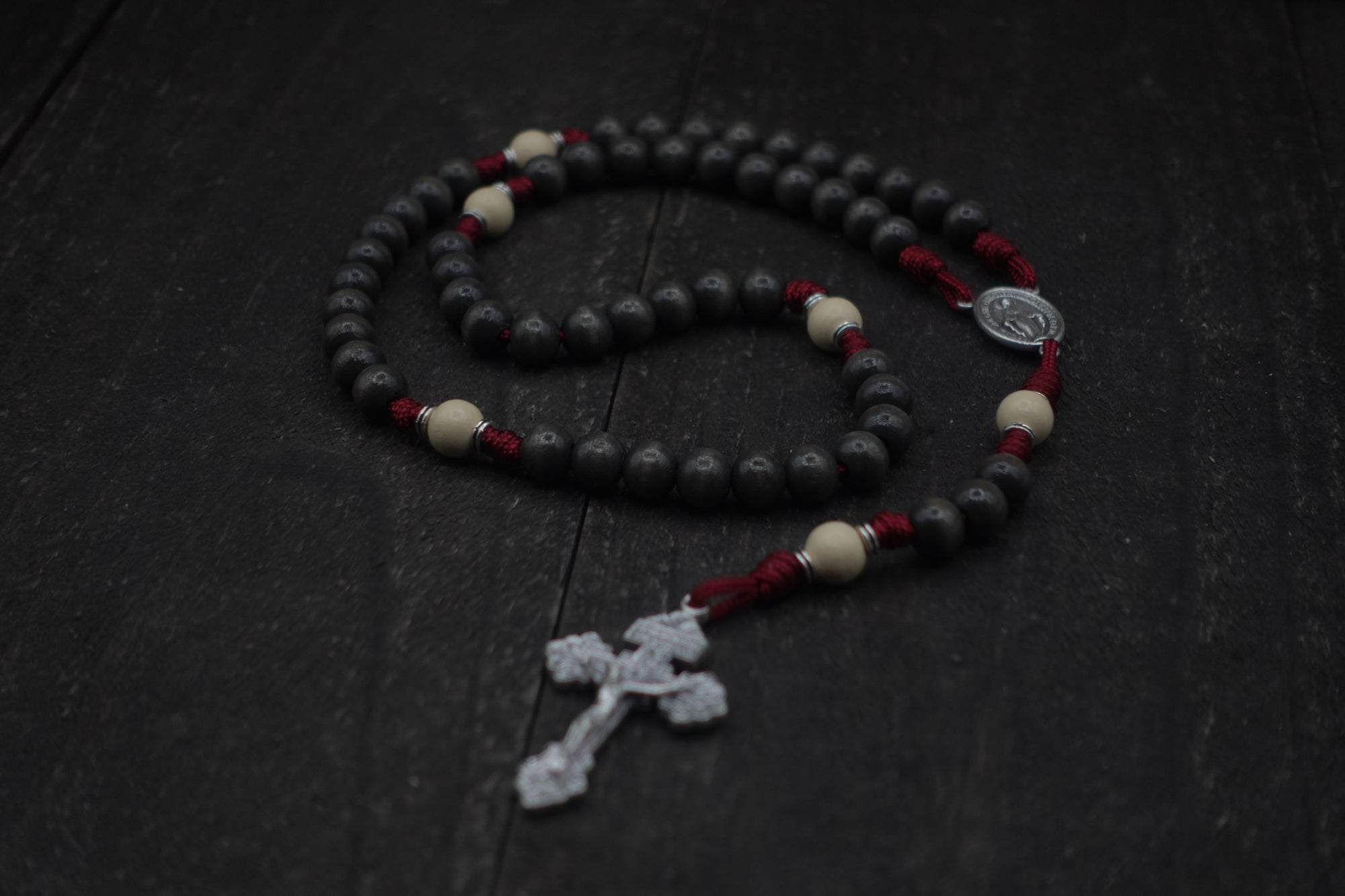 Pope Leo XIV rosary by Runewood Rosary combining charcoal and white wood beads, silver crucifix, and burgundy paracord for faithful devotion
