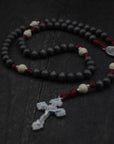 Pope Leo XIV rosary by Runewood Rosary combining charcoal and white wood beads, silver crucifix, and burgundy paracord for faithful devotion