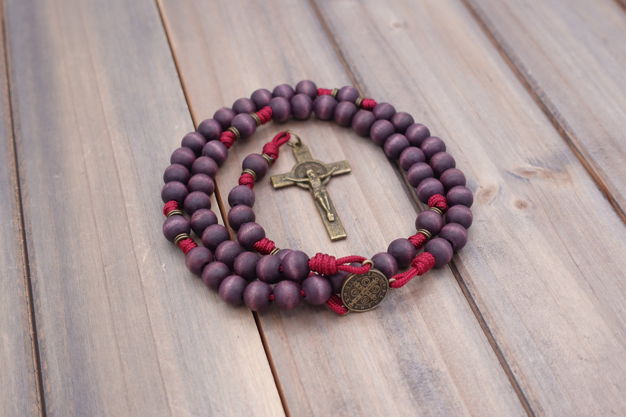 Close-up of bronze St. Benedict crucifix on Roma Victor rosary with purple wood beads