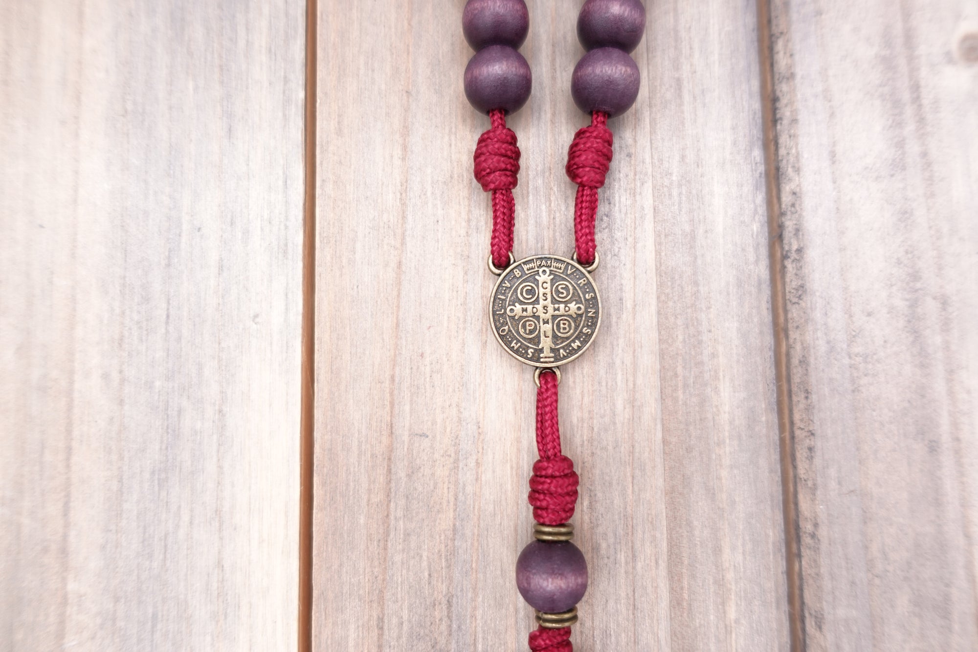 Bronze St. Benedict medal centerpiece detail on Roma Victor rosary with purple wood beads