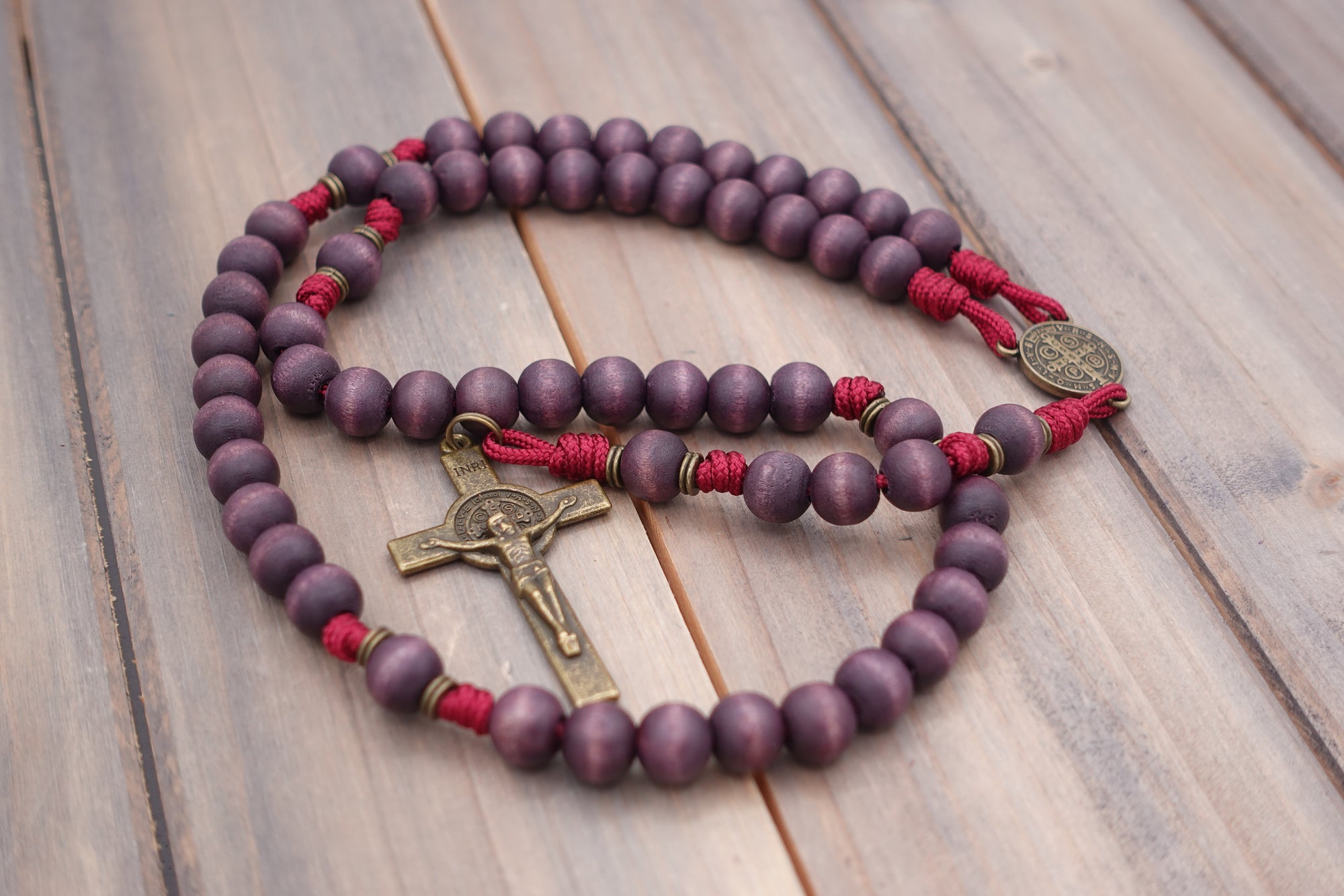 Close-up of bronze medal and paracord craftsmanship on handmade Roma Victor rosary
