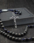 Sanctus rosary with charcoal and black wooden beads, silver St. Benedict crucifix, and navy paracord
