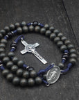 Close-up of silver St. Benedict crucifix on Sanctus rosary with charcoal and black wooden beads