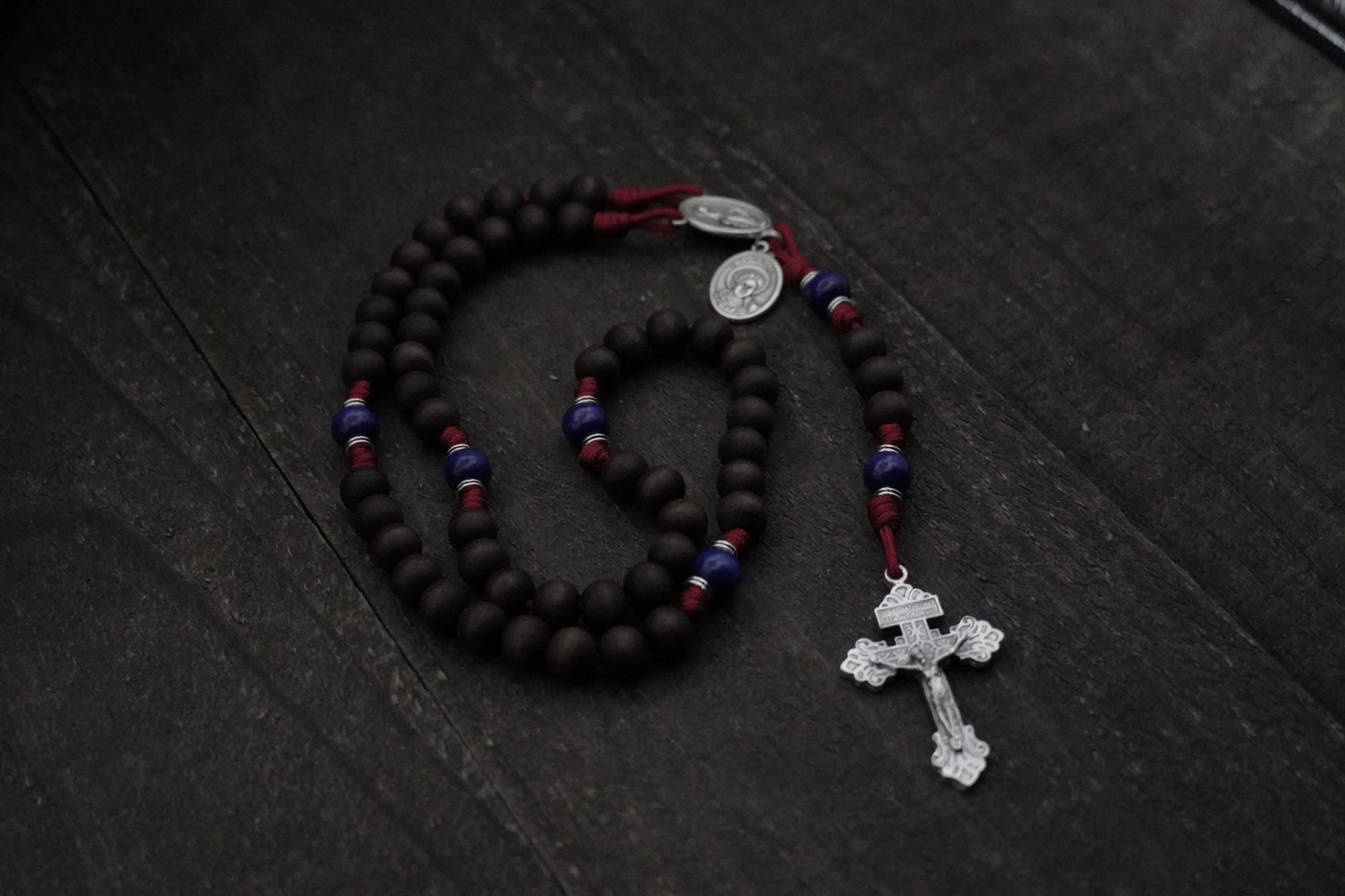 Handcrafted rosary honoring St. Carlo Acutis featuring wood beads, silver crucifix, and Miraculous Medal centerpiece