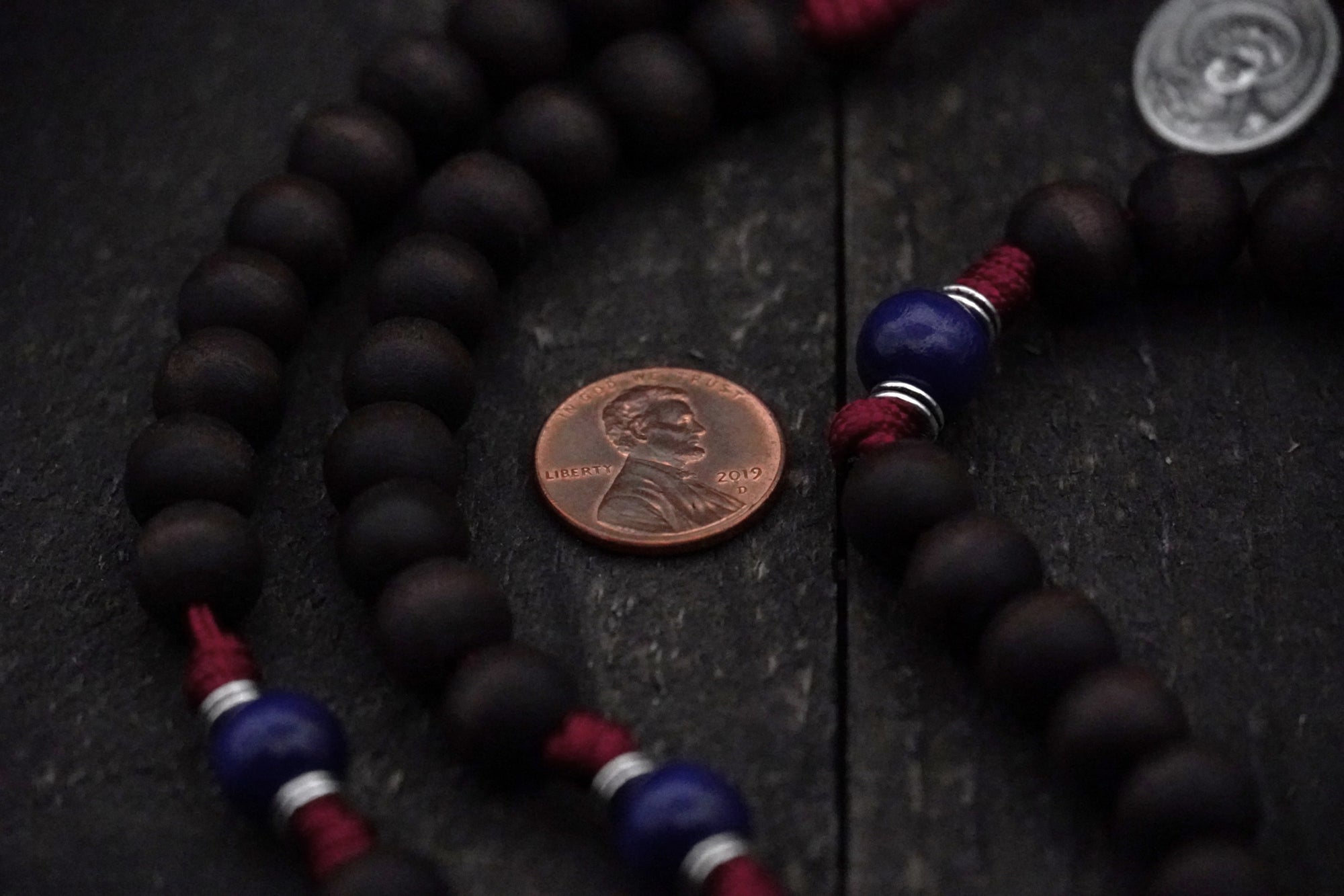 Close-up of walnut and royal blue wooden beads on St. Carlo Acutis rosary showing heirloom craftsmanship
