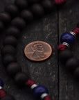 Close-up of walnut and royal blue wooden beads on St. Carlo Acutis rosary showing heirloom craftsmanship