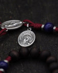 Close-up of silver Pardon crucifix on St. Carlo Acutis rosary with walnut and blue wooden beads