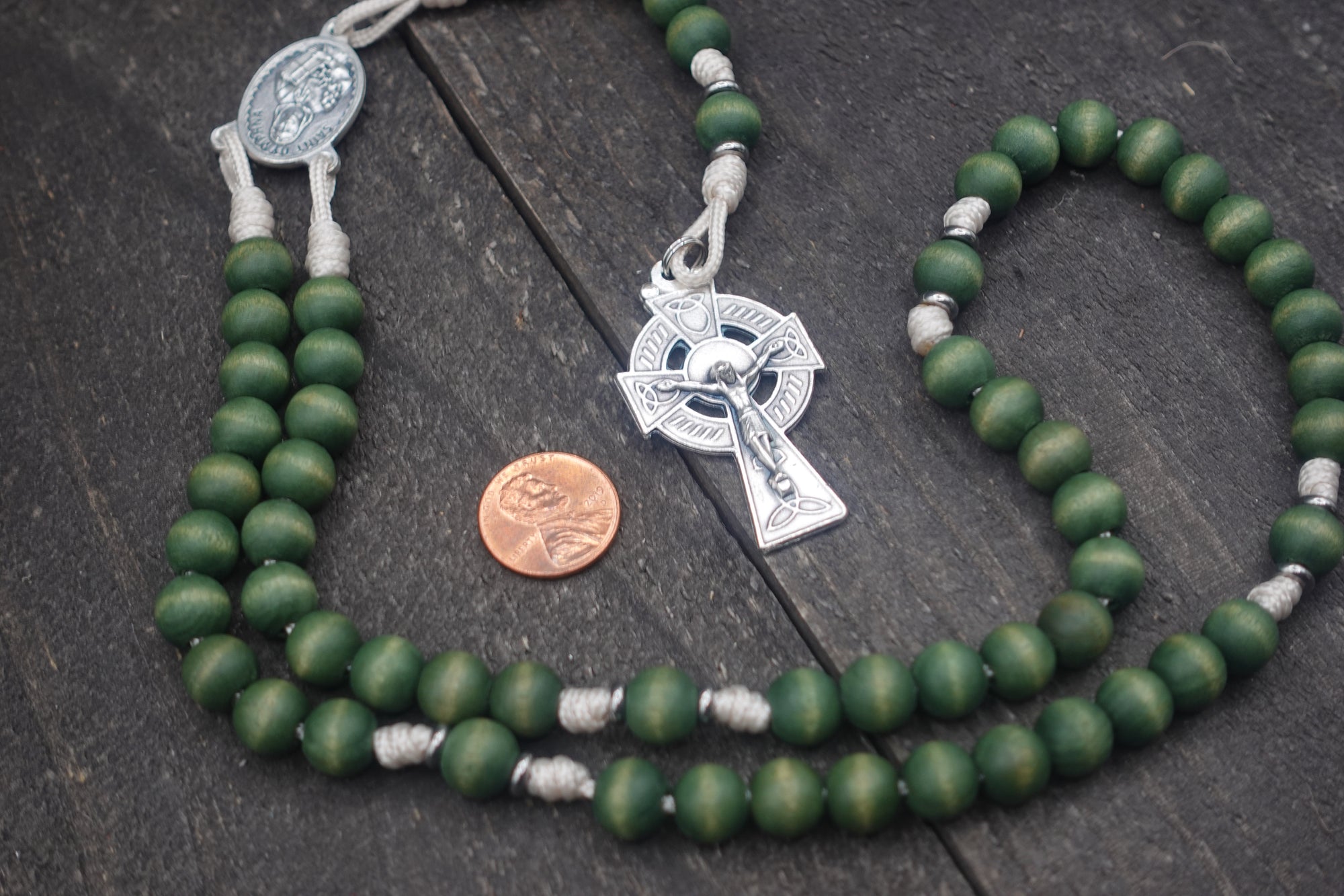 Handcrafted women’s rosary featuring green wood beads, silver crucifix, and St. Dymphna medal centerpiece