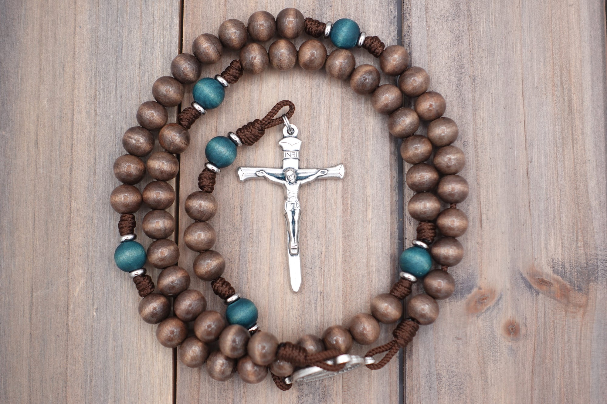 Handcrafted St. Kateri rosary for daily prayer featuring silver crucifix and gray-brown wooden beads