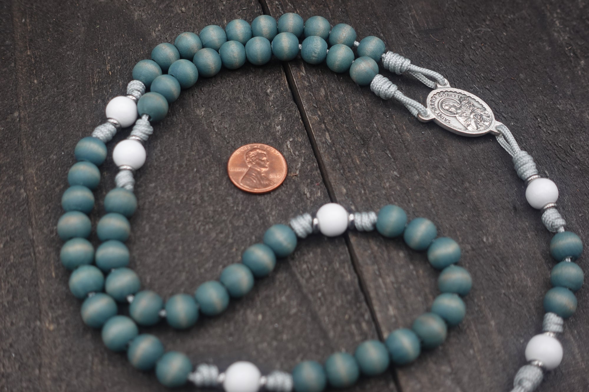 Handcrafted women’s rosary featuring blue and white wood beads with silver crucifix and St. Maria Goretti medal centerpiece