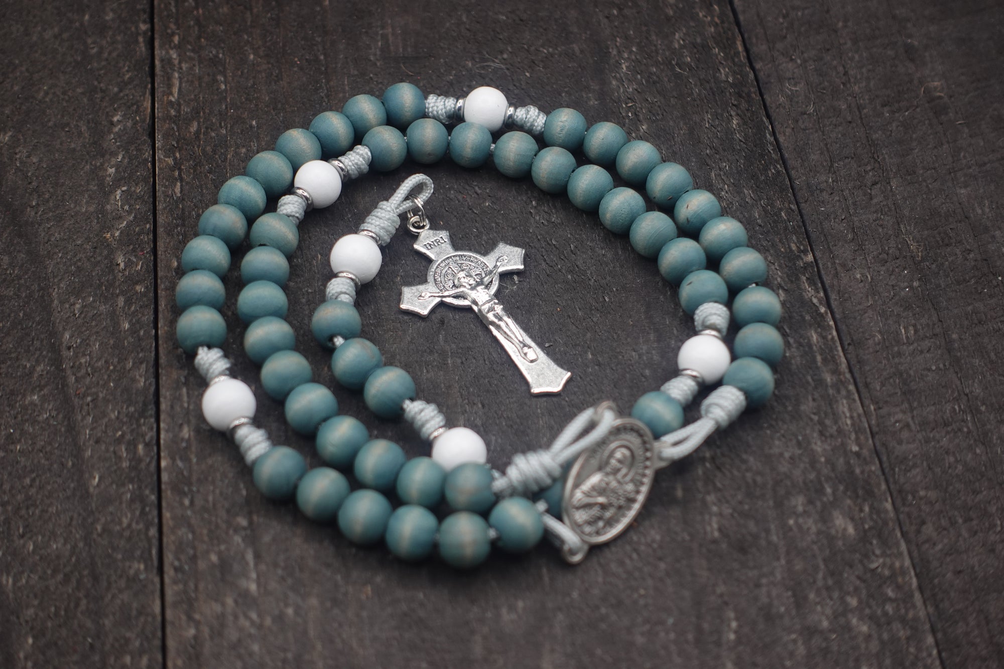 Close-up of faded blue and white wooden beads on St. Maria Goretti rosary showing heirloom craftsmanship