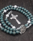 Close-up of faded blue and white wooden beads on St. Maria Goretti rosary showing heirloom craftsmanship
