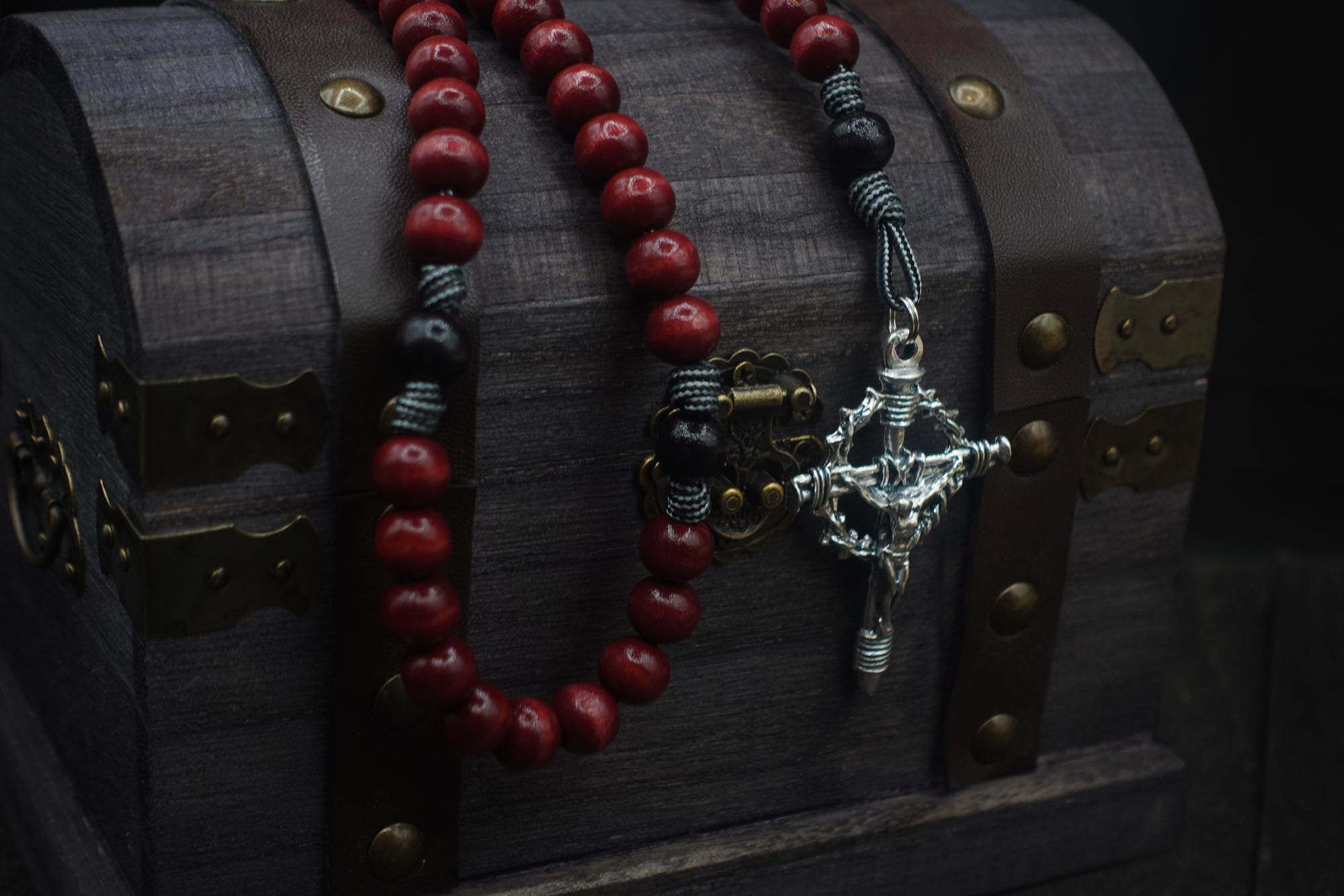 Durable paracord rosary built for daily prayer with silver hardware and red-black stained wooden beads