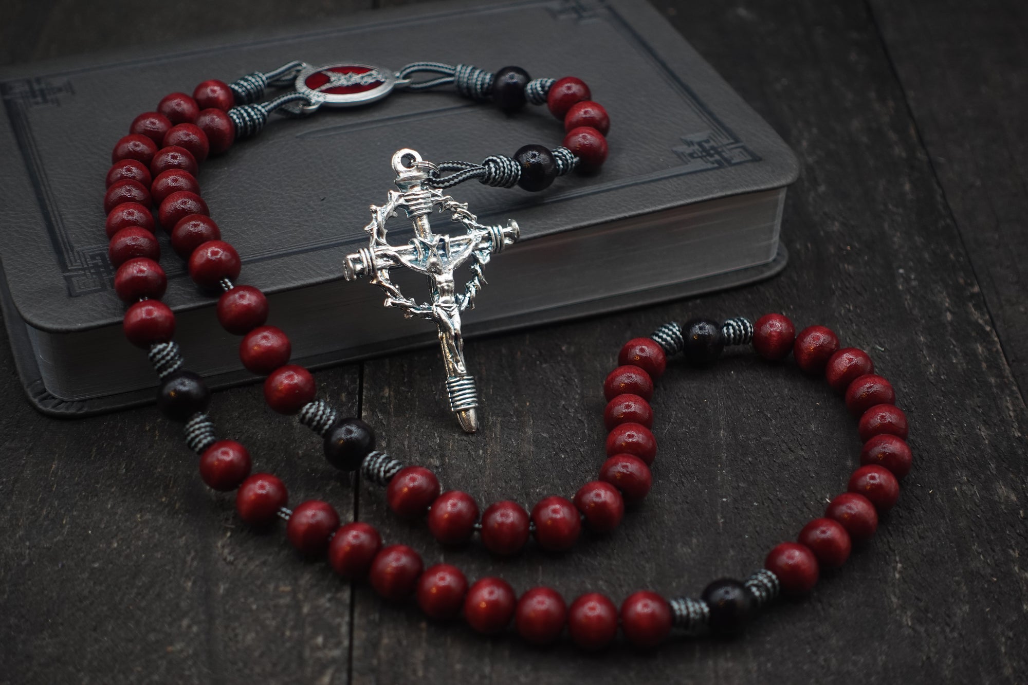 St. Michael rosary with red and black wooden beads, silver Crown of Thorns crucifix, and durable paracord