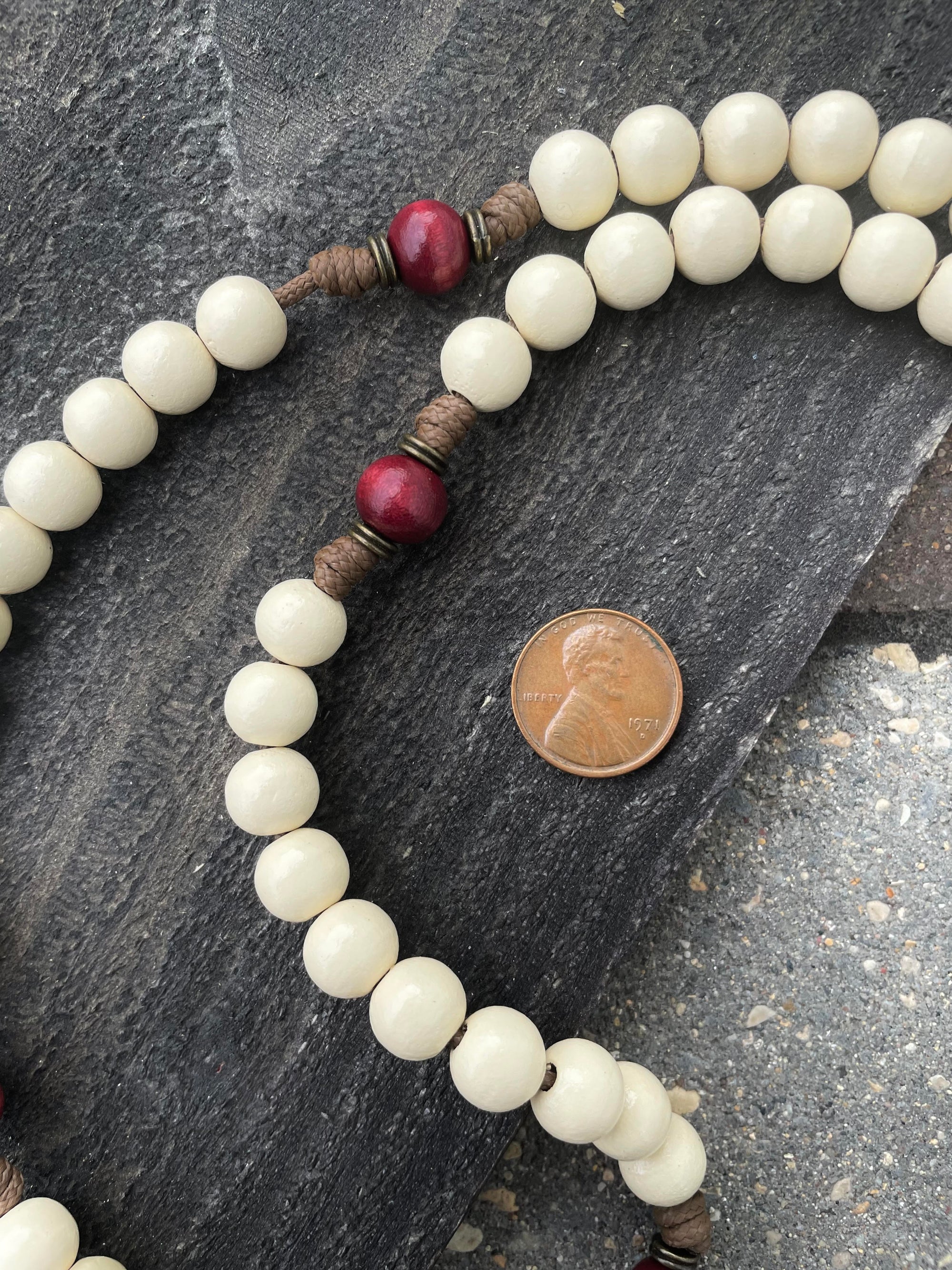 Close-up of red and vintage white wooden beads on St. Nicholas Christmas rosary showing heirloom craftsmanship