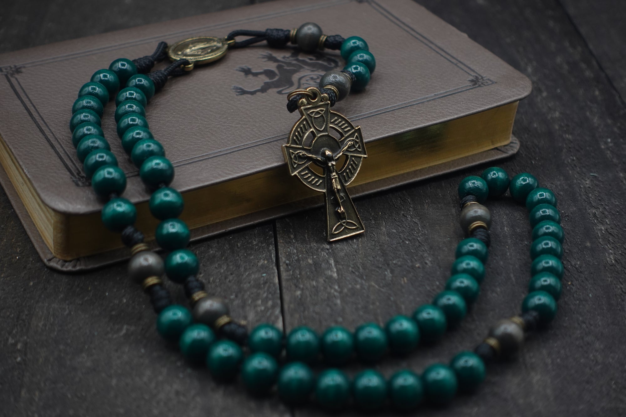 St. Patrick irish rosary with emerald green and charcoal wooden beads, bronze Celtic crucifix, and black paracord