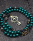 St. Patrick rosary with emerald green and charcoal wooden beads, bronze Celtic crucifix, and black paracord