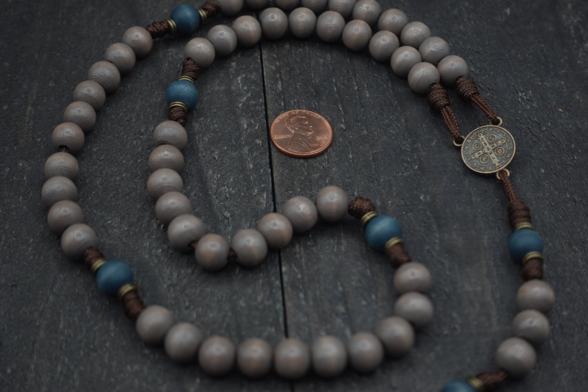 Close-up of light gray and navy wooden beads on Ave Maris Stella rosary showing heirloom craftsmanship