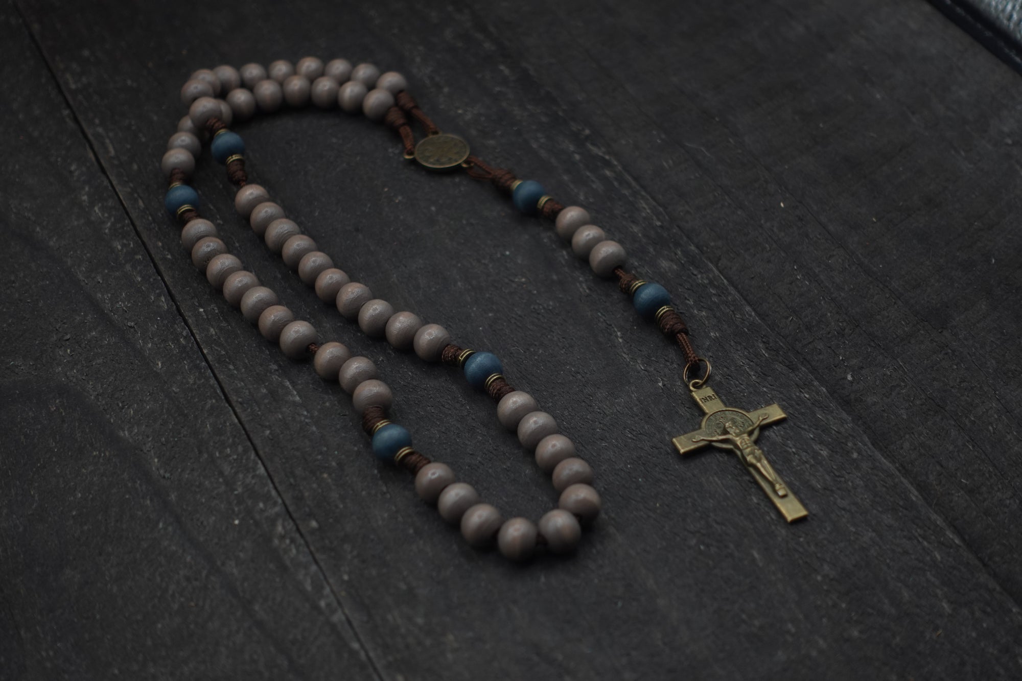 Ave Maris Stella rosary by Runewood Rosary combining gray and navy wood beads, bronze crucifix, and walnut paracord for faithful devotion