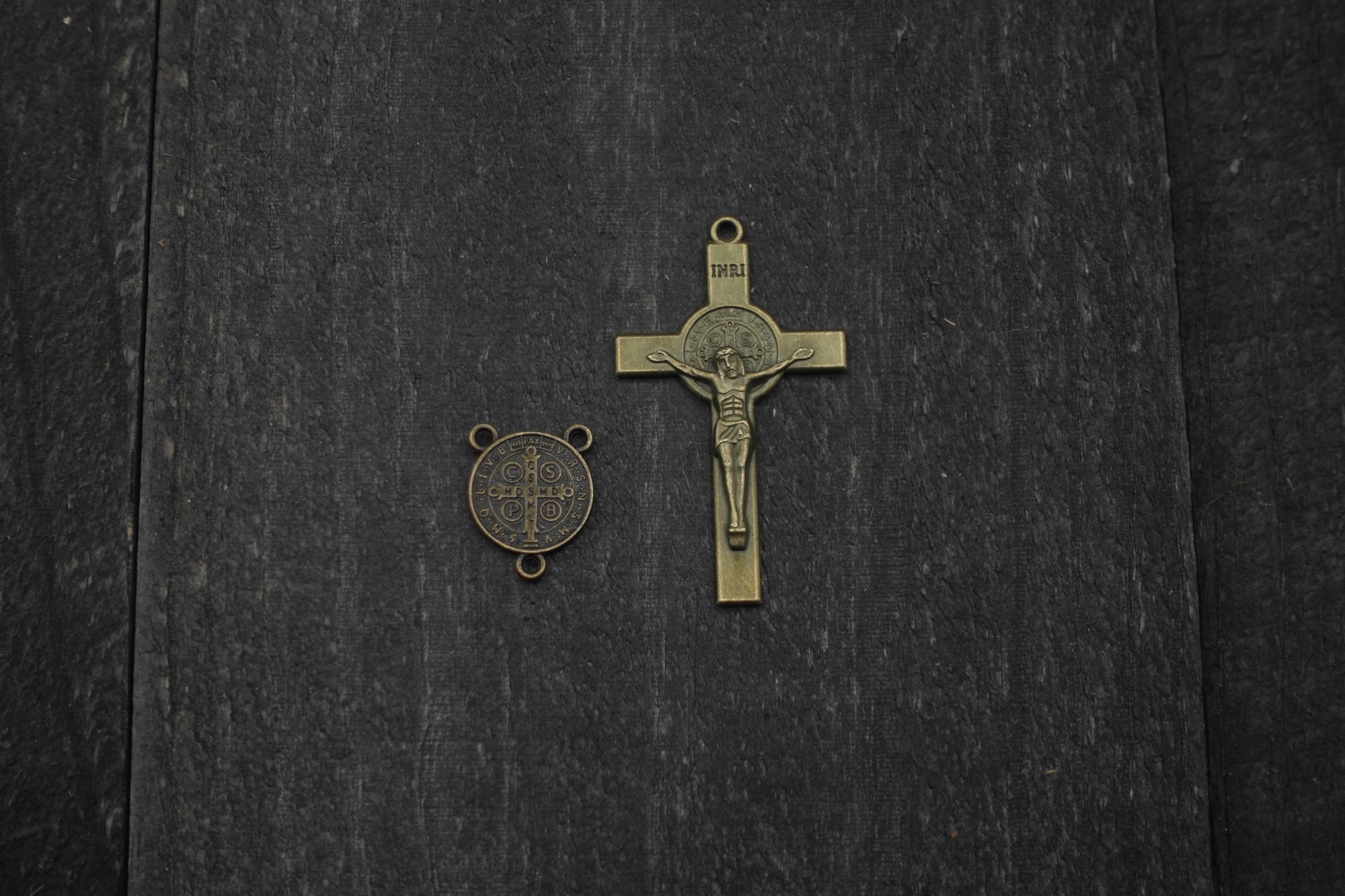 Close-up of bronze St. Benedict crucifix on Ave Maris Stella rosary with light gray and navy wood beads
