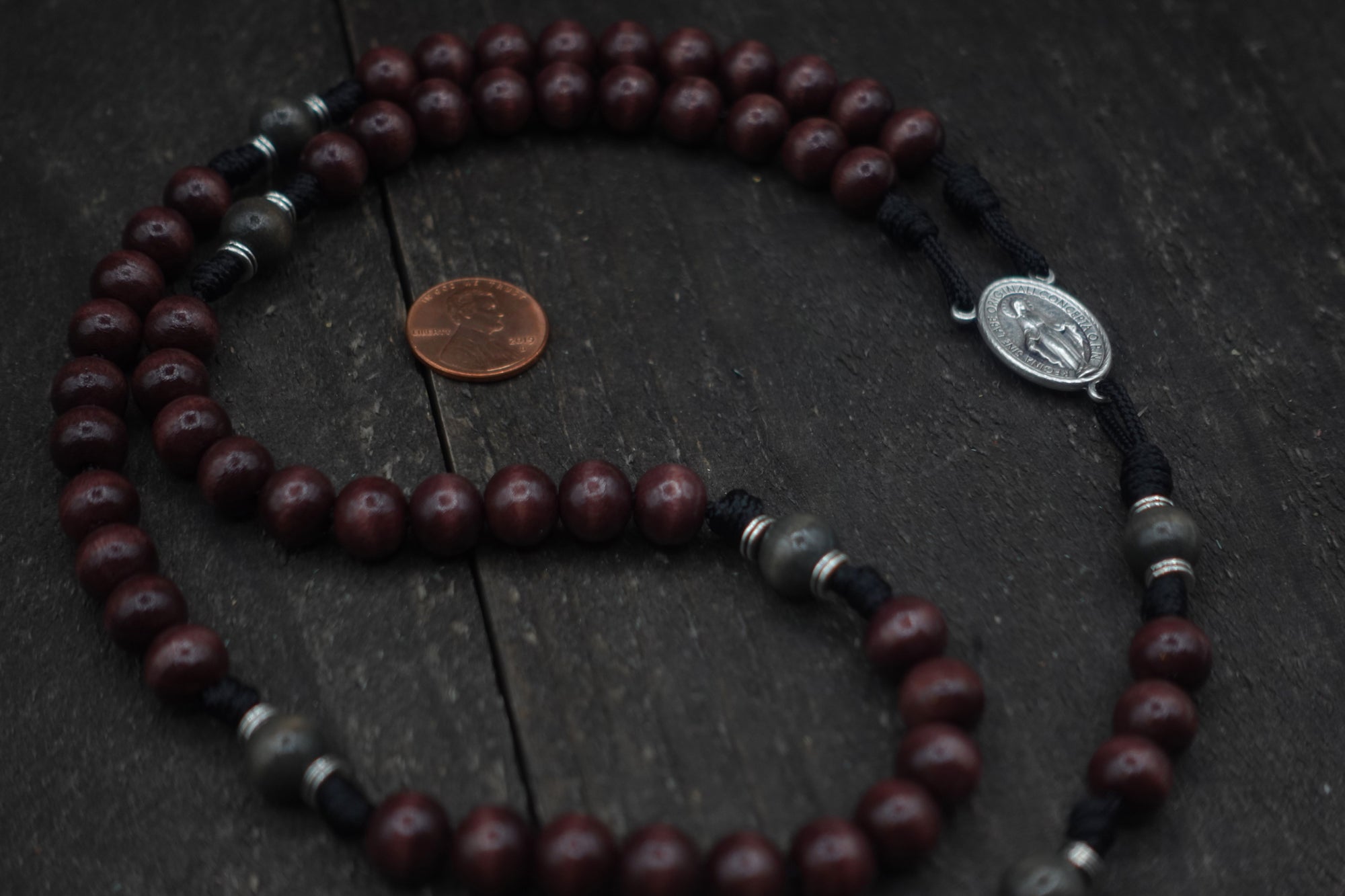 Handcrafted Catholic men’s rosary featuring dark wood beads, silver crucifix, and Miraculous Medal centerpiece