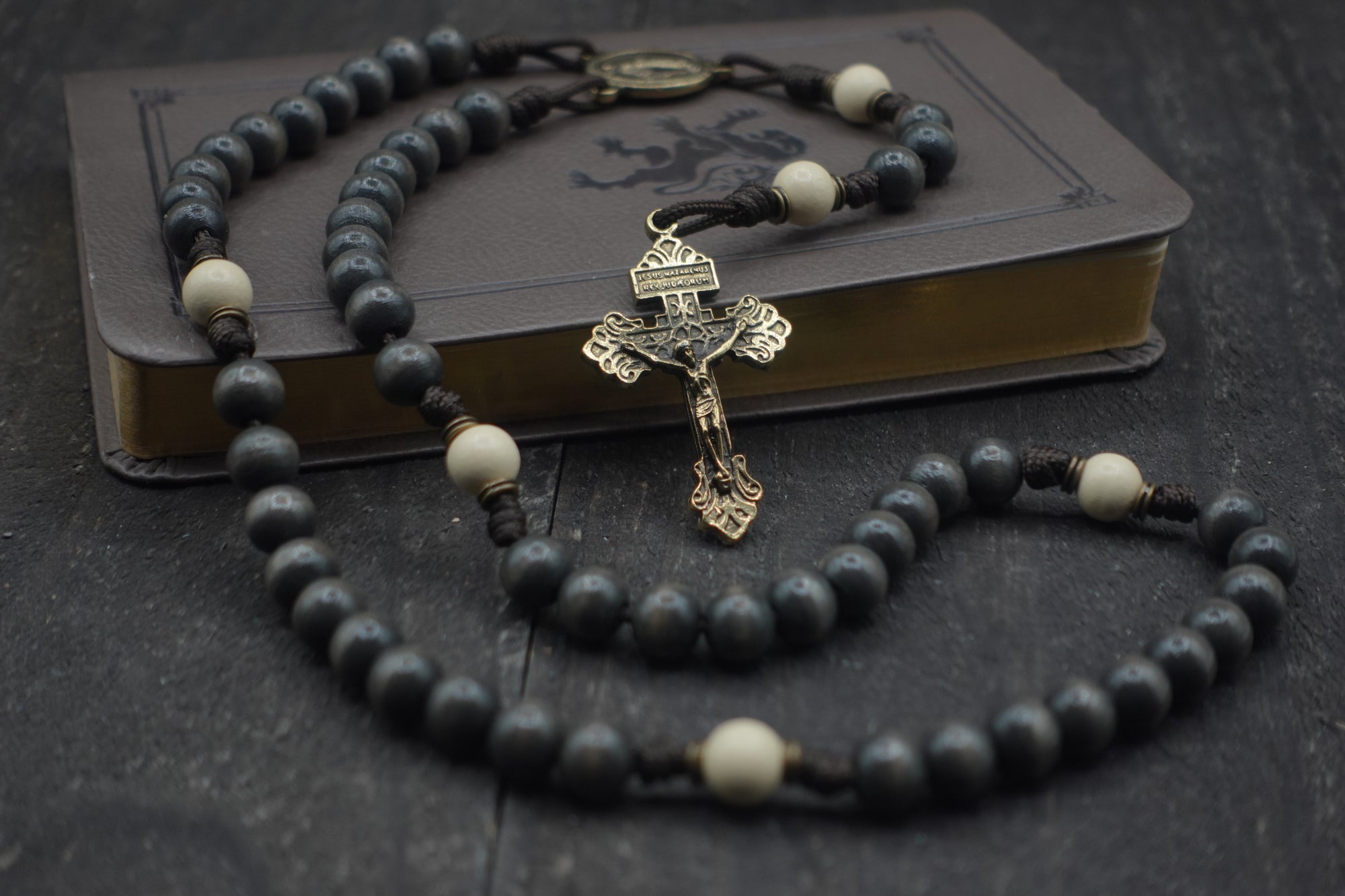 Handcrafted rosary honoring Pope Leo XIV featuring charcoal wood beads, bronze crucifix, and Miraculous Medal centerpiece