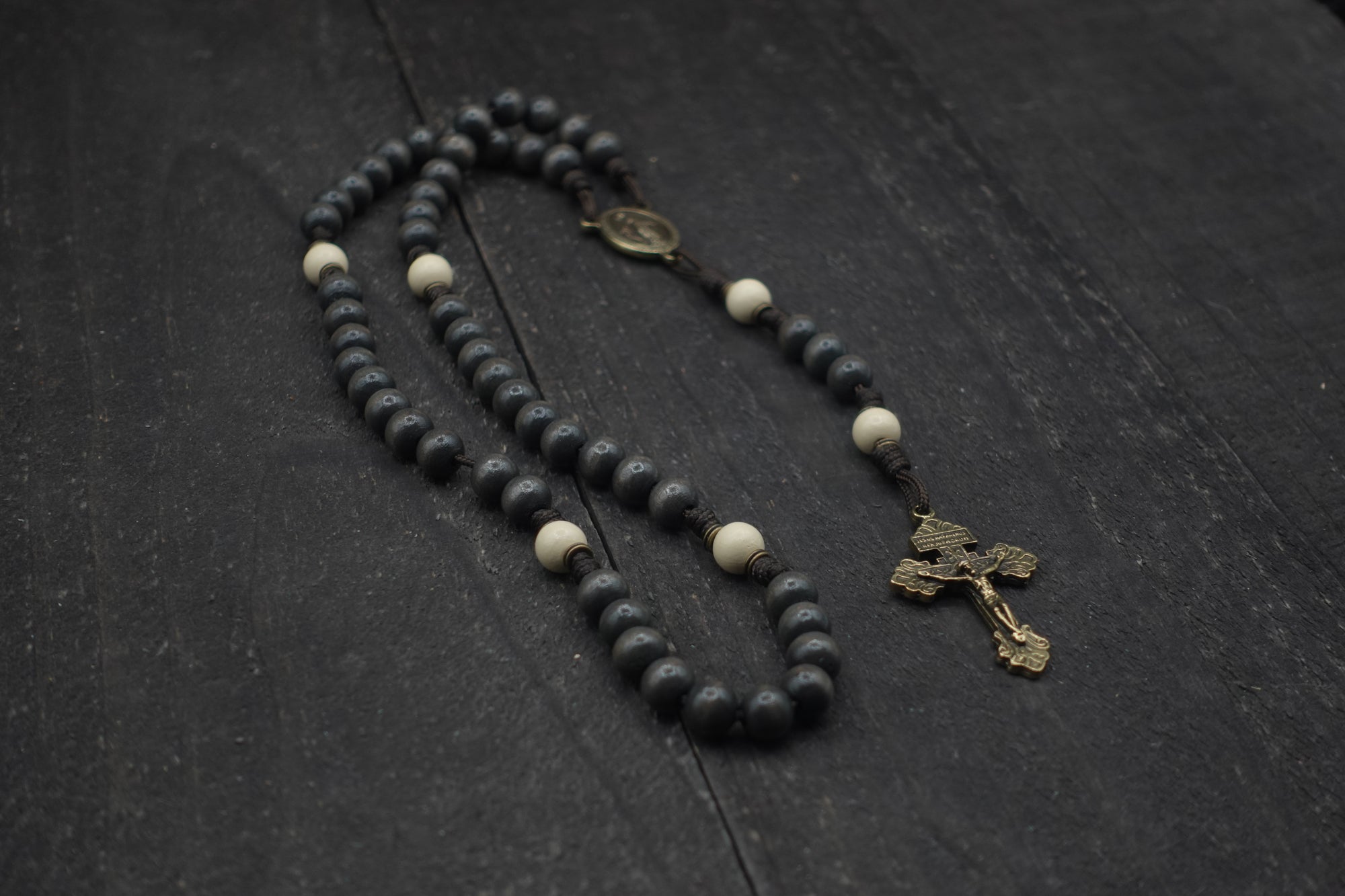 Augustinian rosary with charcoal and white wooden beads, bronze Pardon crucifix, and acid brown paracord