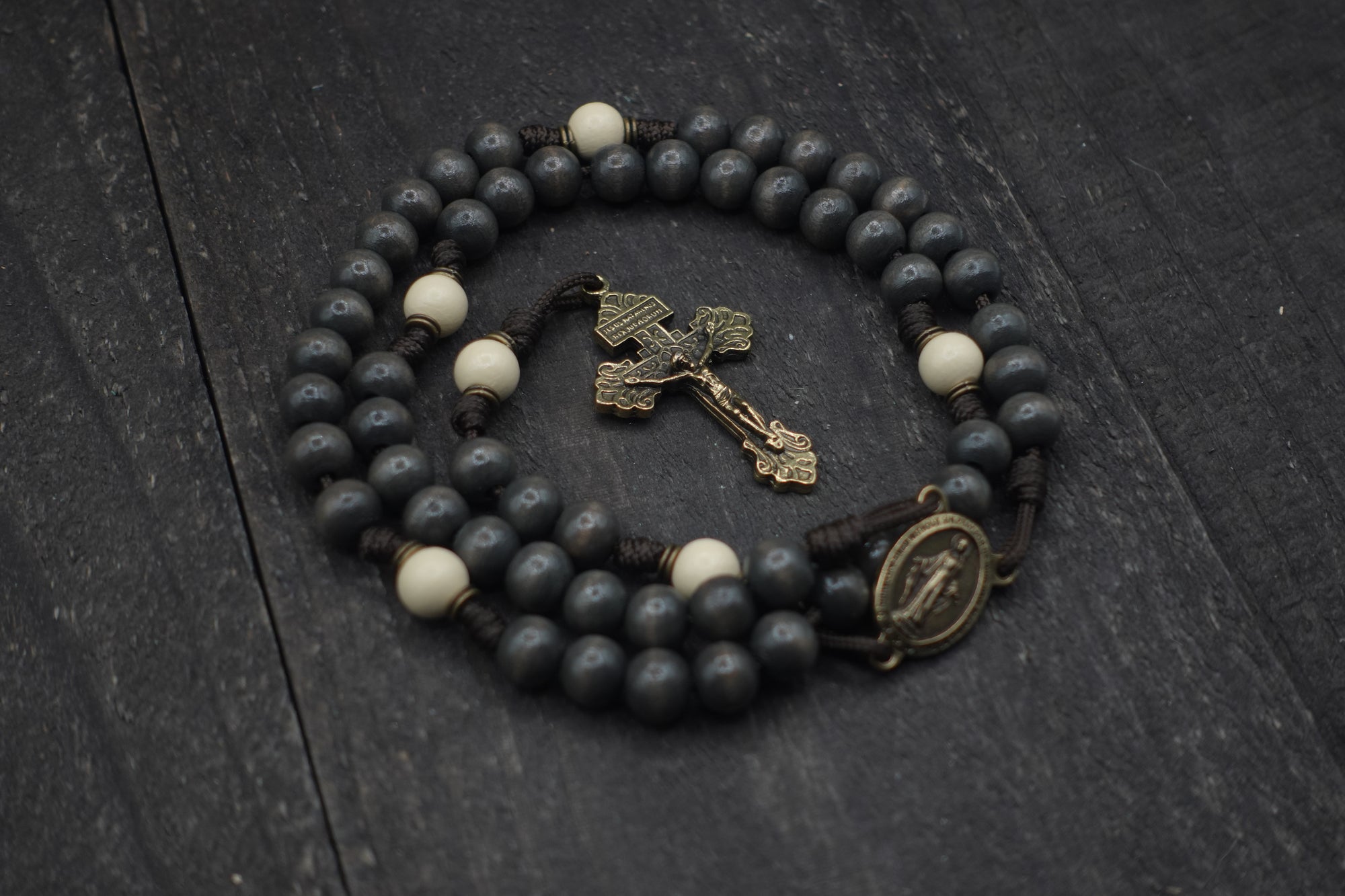 Augustinian rosary by Runewood Rosary combining charcoal and white wood beads, bronze crucifix, and paracord for faithful devotion