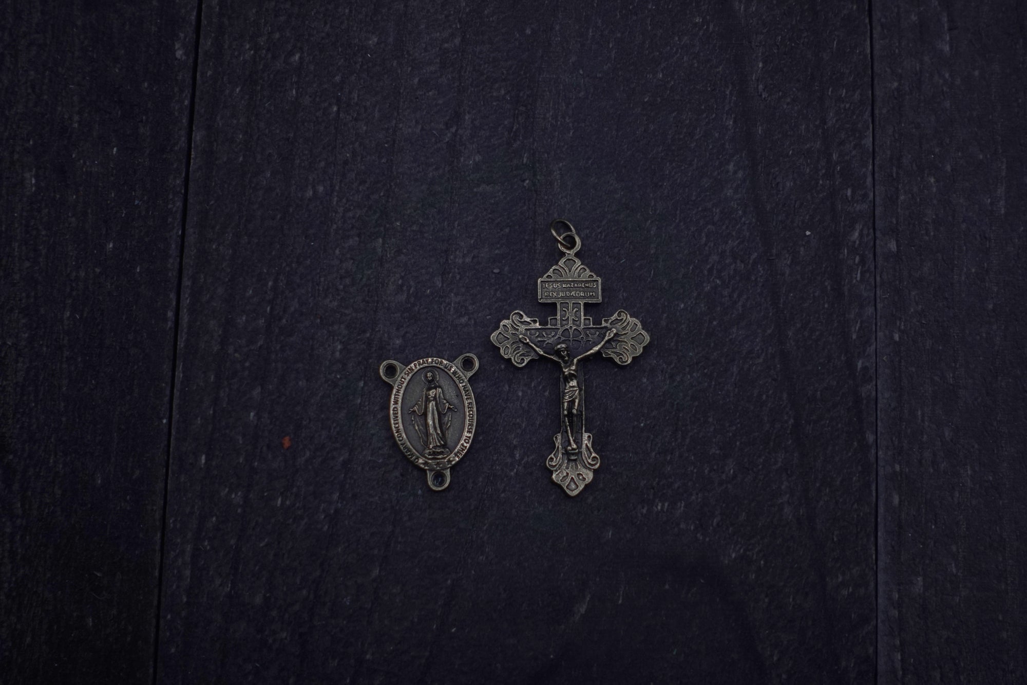 Close-up of bronze Pardon crucifix on Pope Leo XIV rosary with vintage white and charcoal wood beads