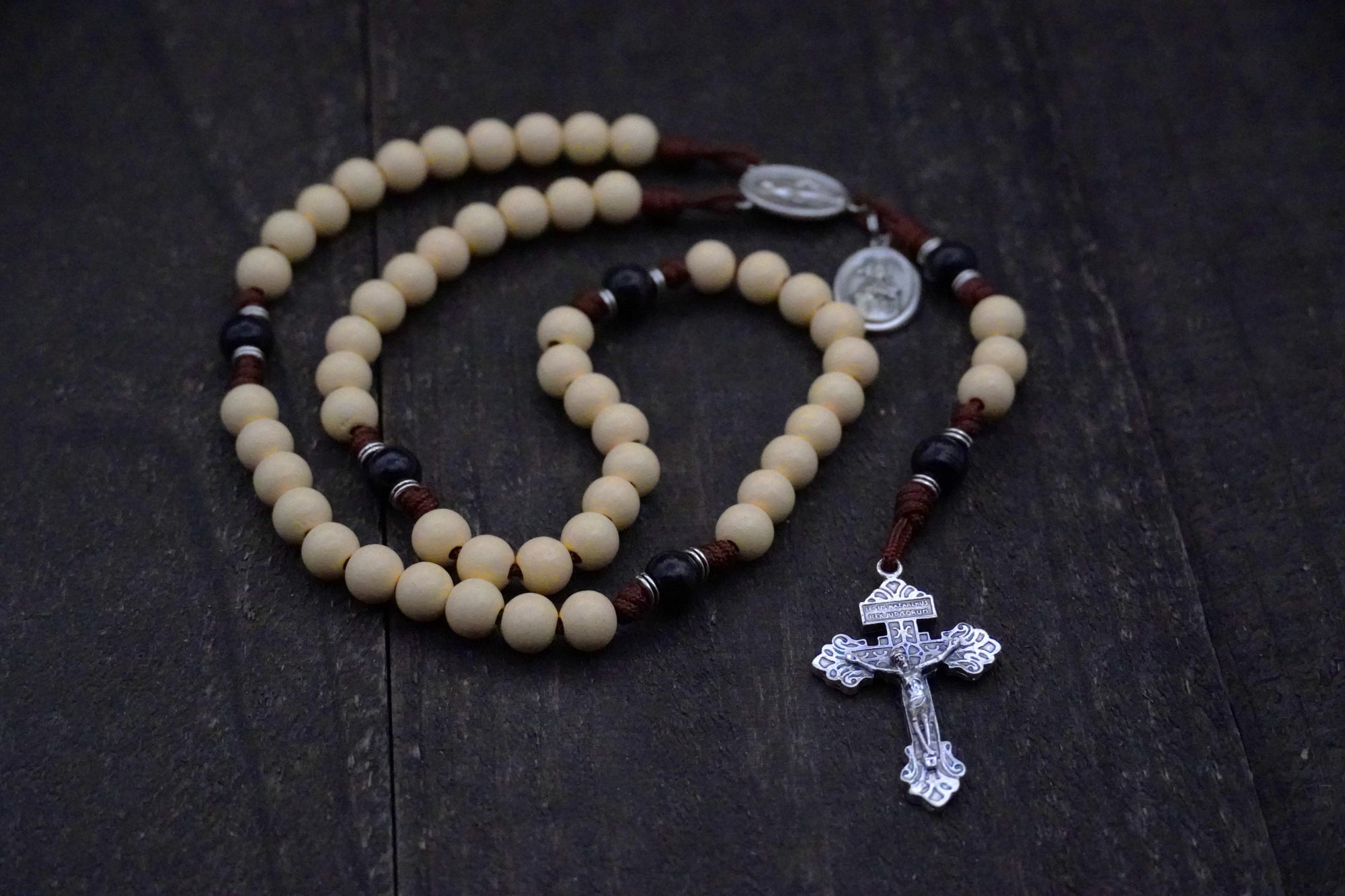 Handcrafted rosary honoring St. Teresa of Ávila featuring cream Hail Mary beads, black Our Father beads, and silver crucifix
