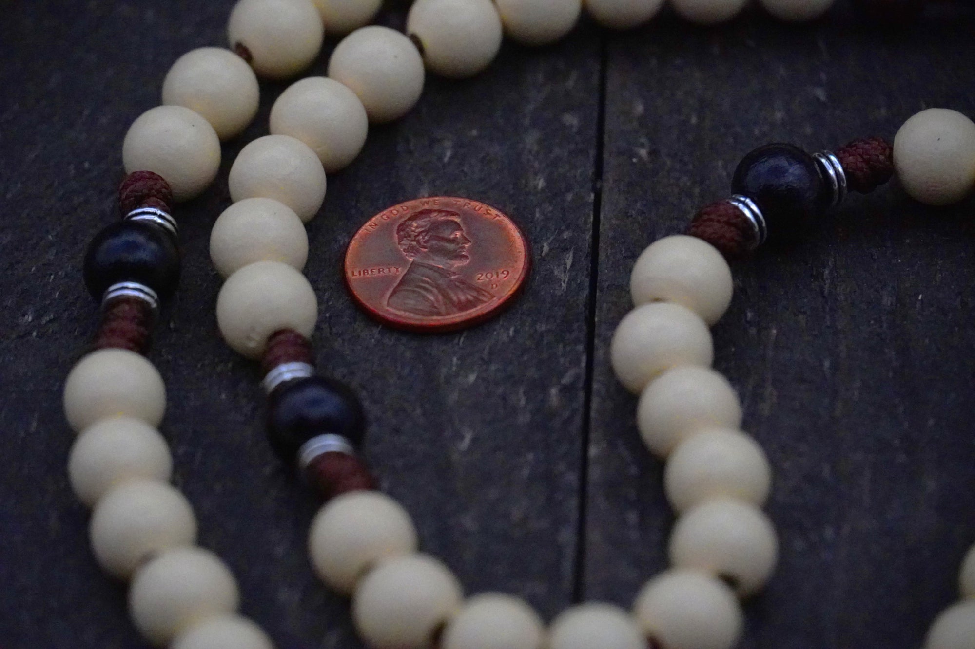 Close-up of vintage white and black wooden beads on St. Teresa of Ávila rosary showing heirloom craftsmanship