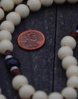 Close-up of vintage white and black wooden beads on St. Teresa of Ávila rosary showing heirloom craftsmanship