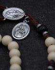 Close-up of vintage white and black wooden beads on St. Teresa of Ávila rosary showing heirloom craftsmanship