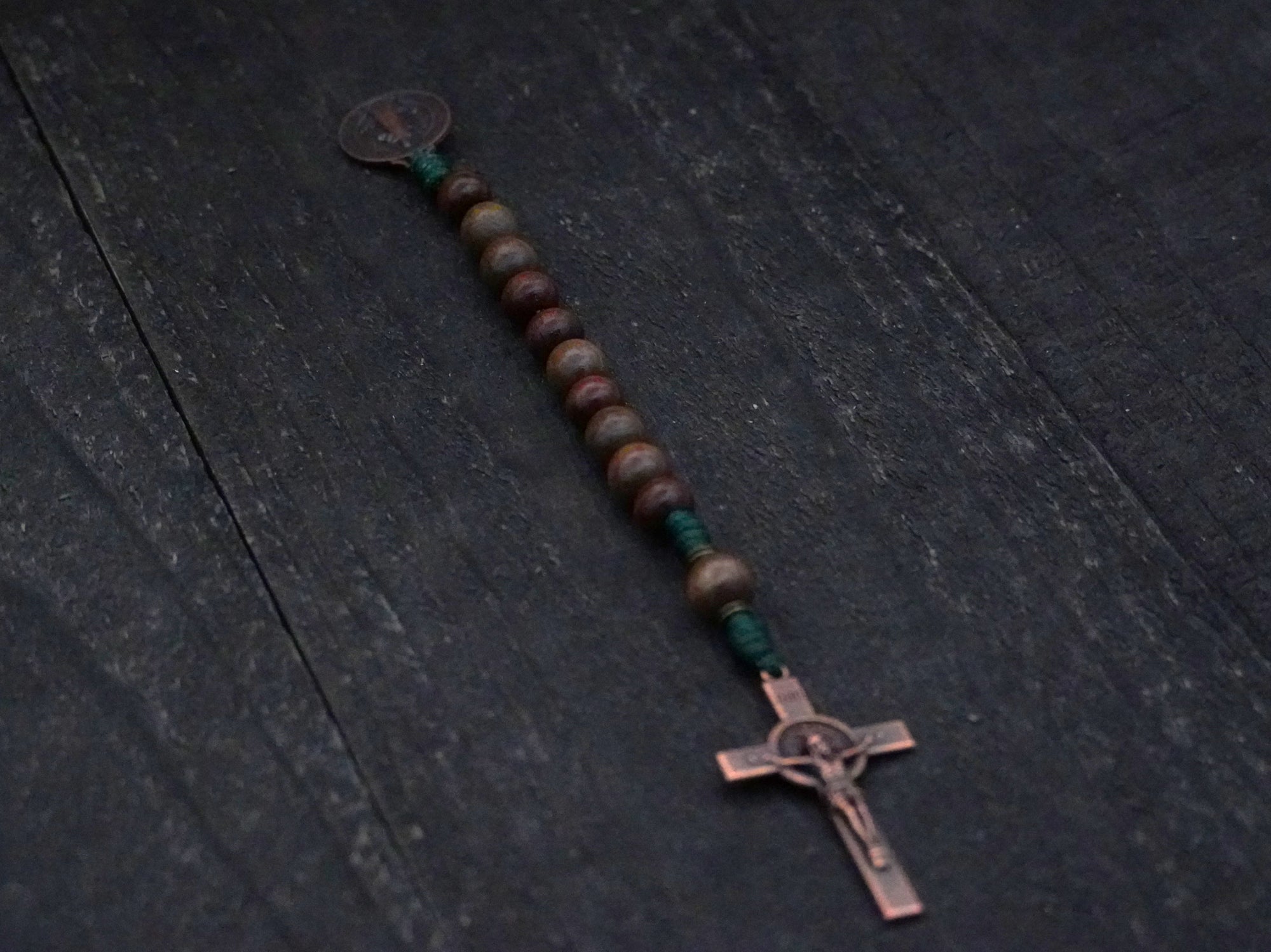 Compact paracord rosary for men, featuring copper hardware and mixed brown wood beads