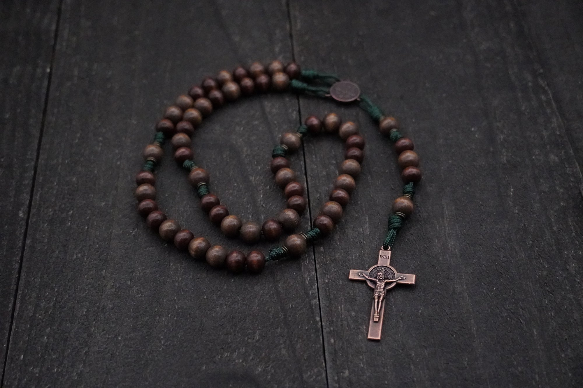 Handmade paracord rosary featuring gray and brown wood beads with copper crucifix and bronze bead caps
