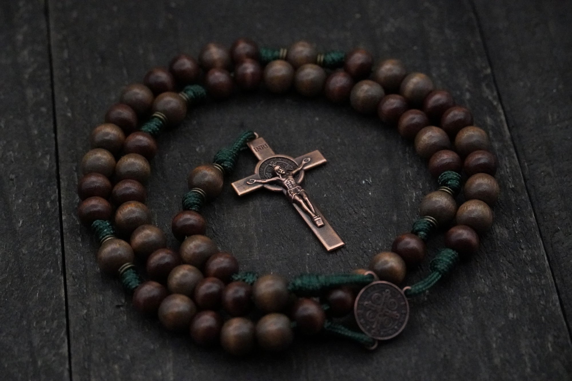 Close-up of copper St. Benedict medal and paracord craftsmanship on handmade rosary